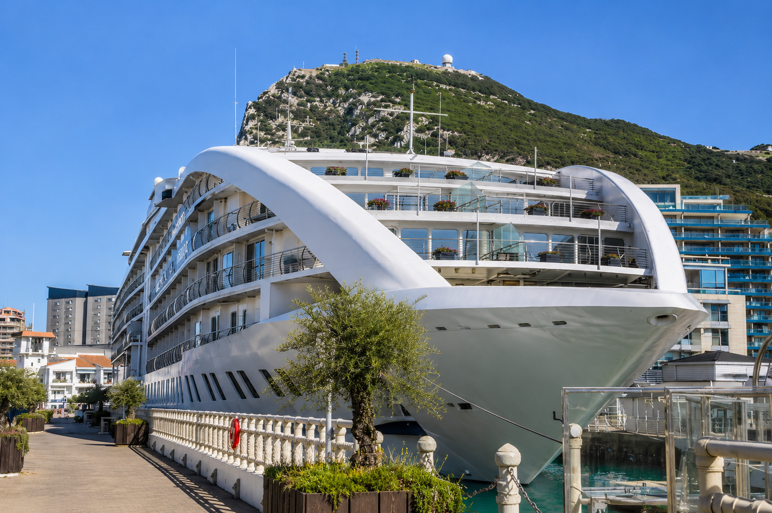 Sunborn Gibraltar luxury yacht hotel at Ocean Village Marina with the Rock of Gibraltar under clear blue skies.
