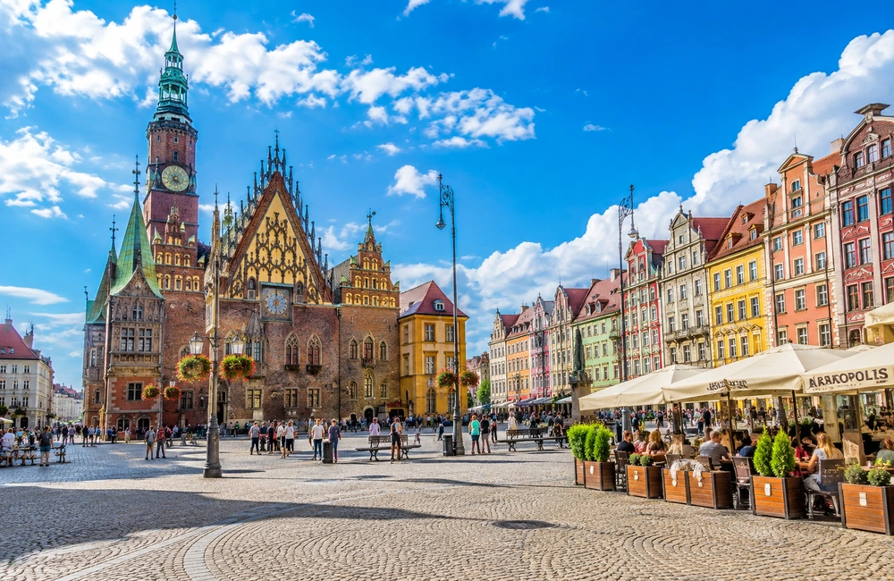 Wrocław Market Square in Poland on a sunny day, with the historic Old Town Hall and colourful architecture.