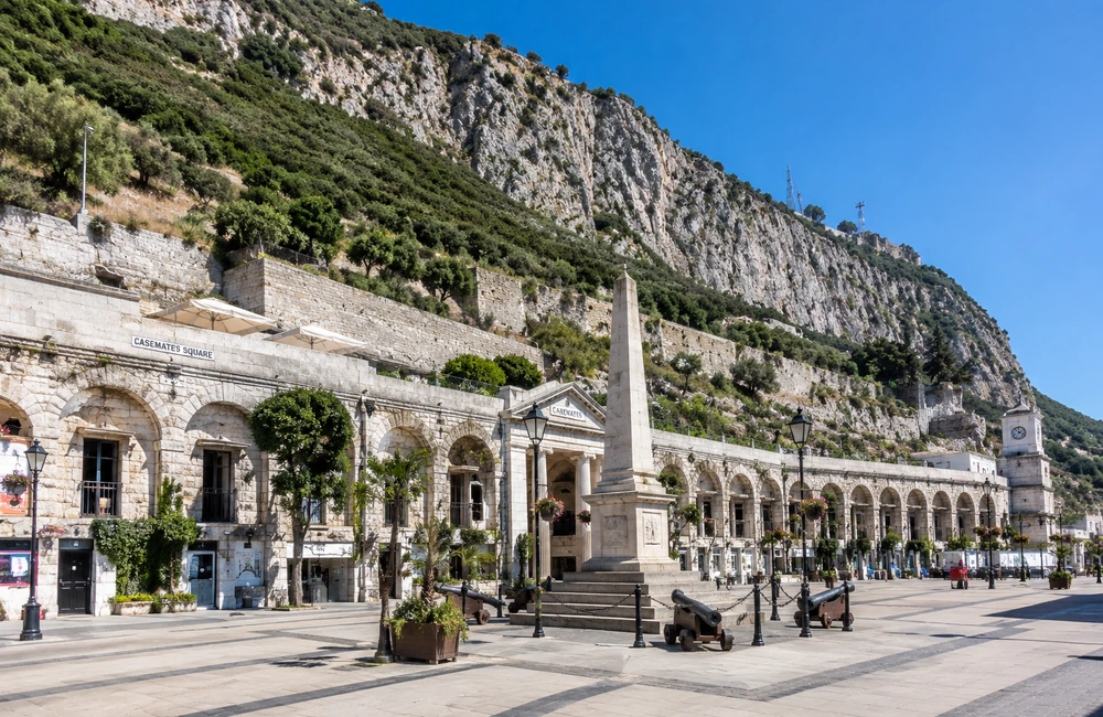 Casemates Square in Gibraltar on a sunny day, with historic stone buildings beneath the Rock of Gibraltar.