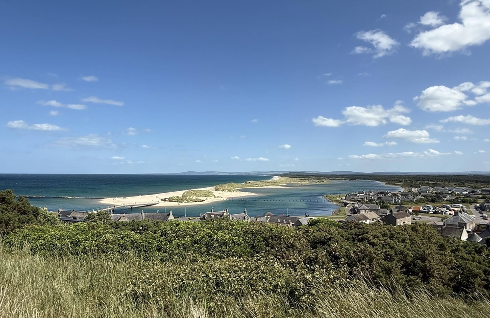 Panoramic view across the Lossiemouth Riviera in Moray, Scotland, with golden sandy beaches, blue sea and the coastal town of Lossiemouth.