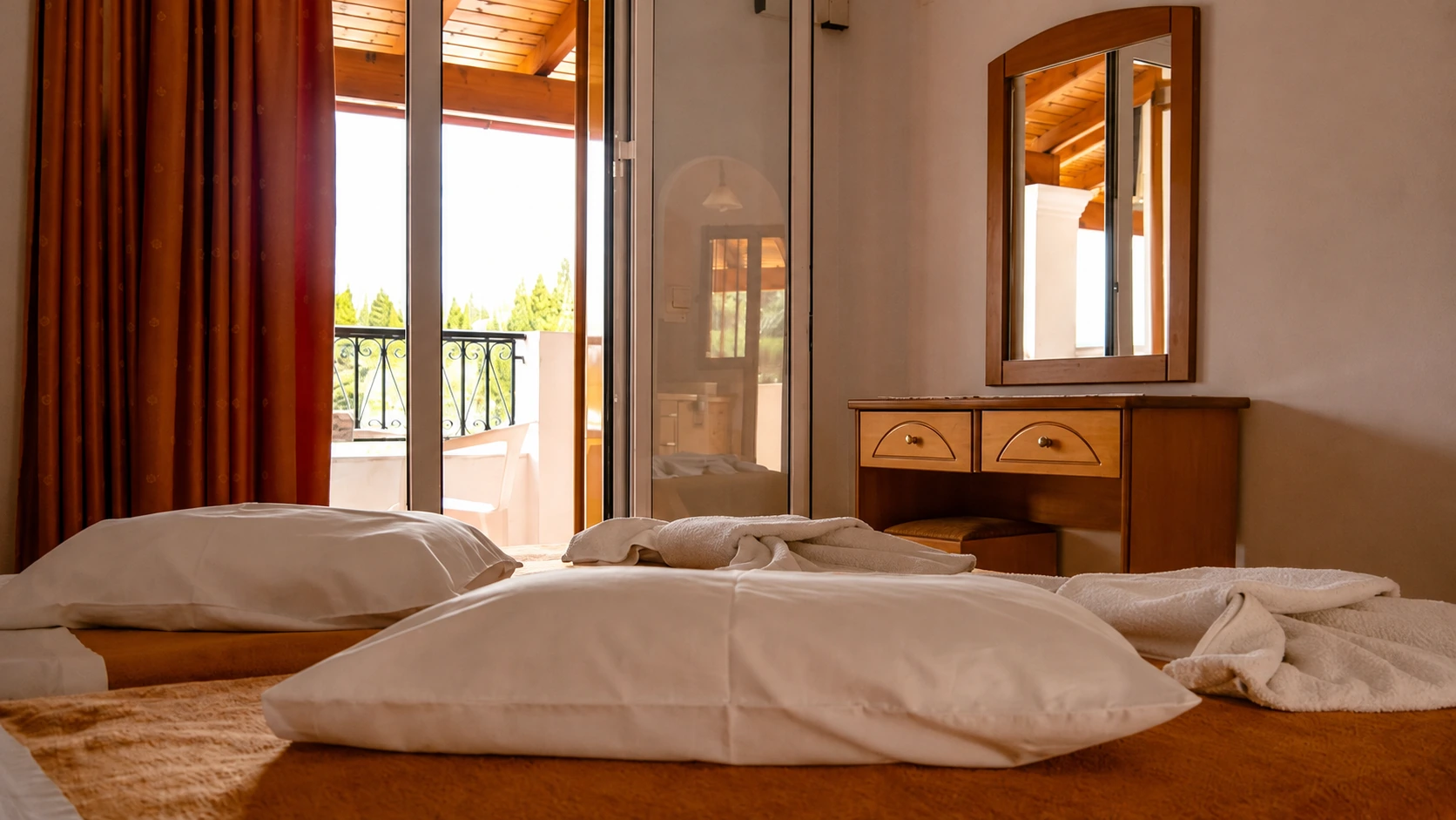 Bright guest bedroom at Tria Adelphia in Arillas, Corfu, with private balcony and traditional Mediterranean-style furnishings.